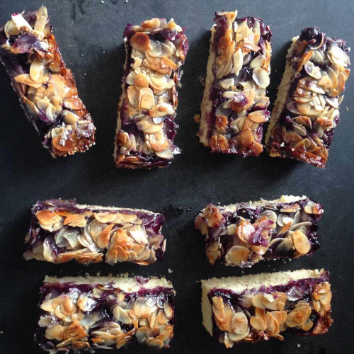 Blueberry almond slices on a black board.